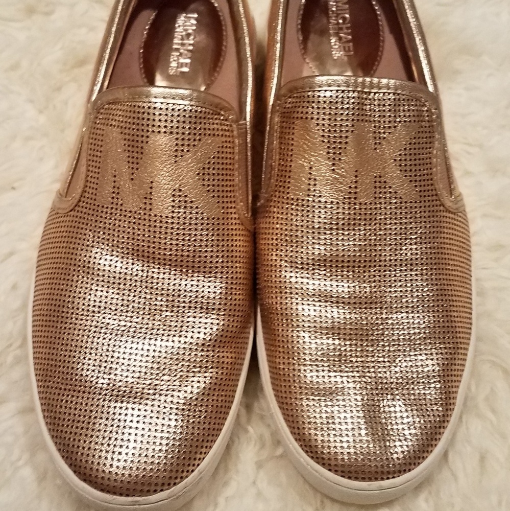 Rose gold Michael Kors slip on shoes.